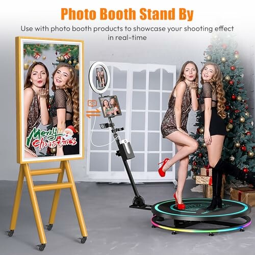 Two women posing with a Christmas-themed photo booth and decorations.