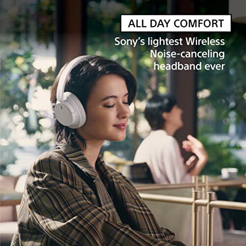 Person wearing Sony wireless noise-canceling headphones indoors.