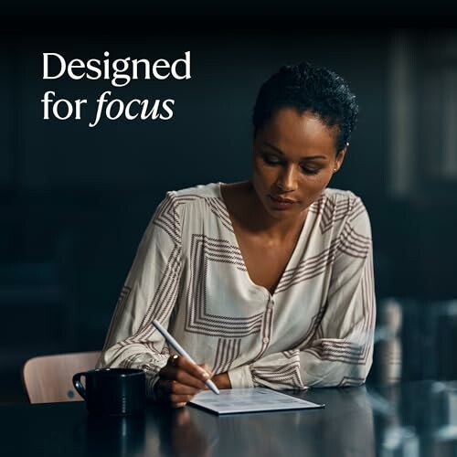 Woman writing at desk with text 'Designed for focus'.